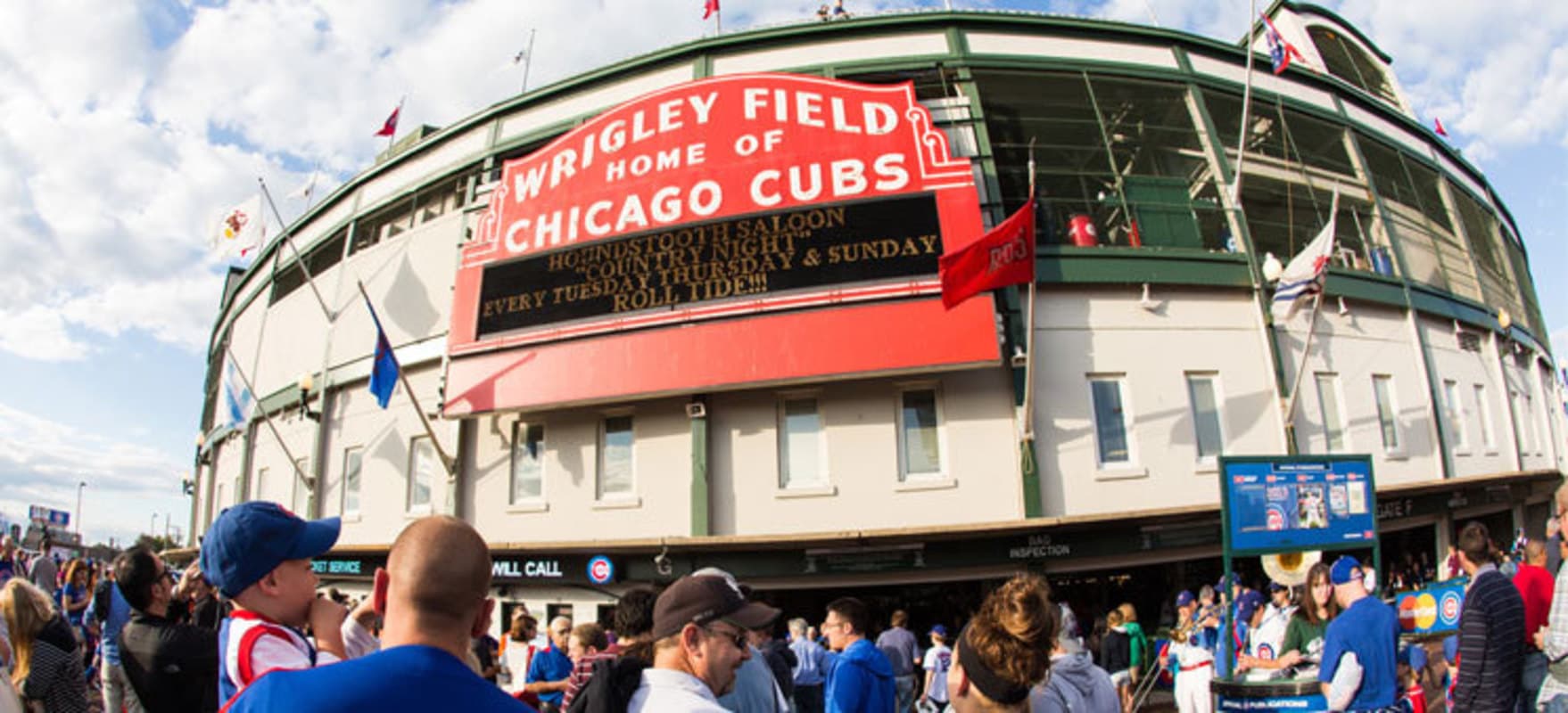 Iconic red Wrigley Field marquee above a crowd of fans outside the Chicago Cubs stadium.
