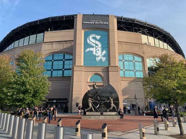 Chicago White Sox stadium exterior featuring a large team logo and a baseball player sculpture.