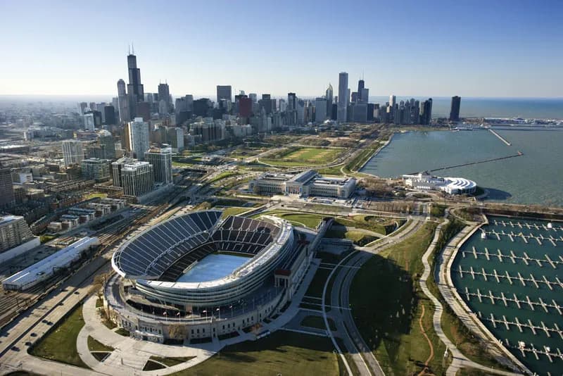 Aerial view of Soldier Field in Chicago with the city skyline and Lake Michigan.